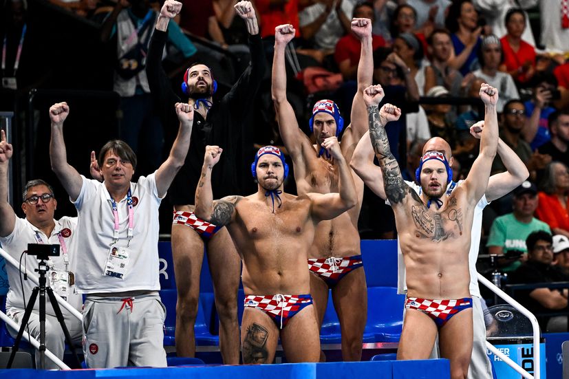 Sportovci týmu Chorvatska fandí během semifinálového zápasu mužů ve vodním pólu mezi týmem Maďarsko (bílé čepice) a týmem Chorvatska (modré čepice) na olympijských hrách v Paříži 2024 v La Defense Areně v Paříži (Francie), 9. srpna 2024.